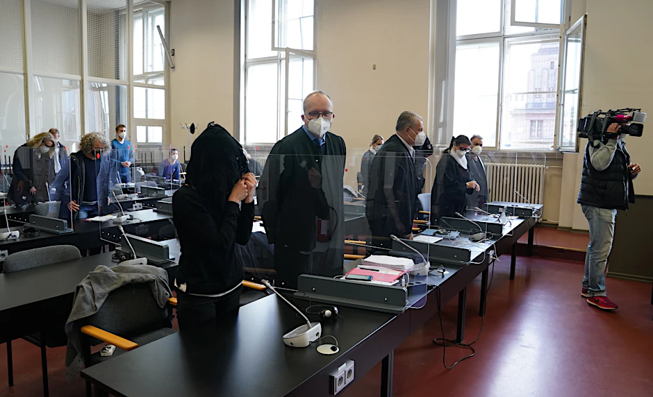 Die Angeklagte (vorne) steht zu Beginn des Prozesses im Sitzungssaal.&nbsp;