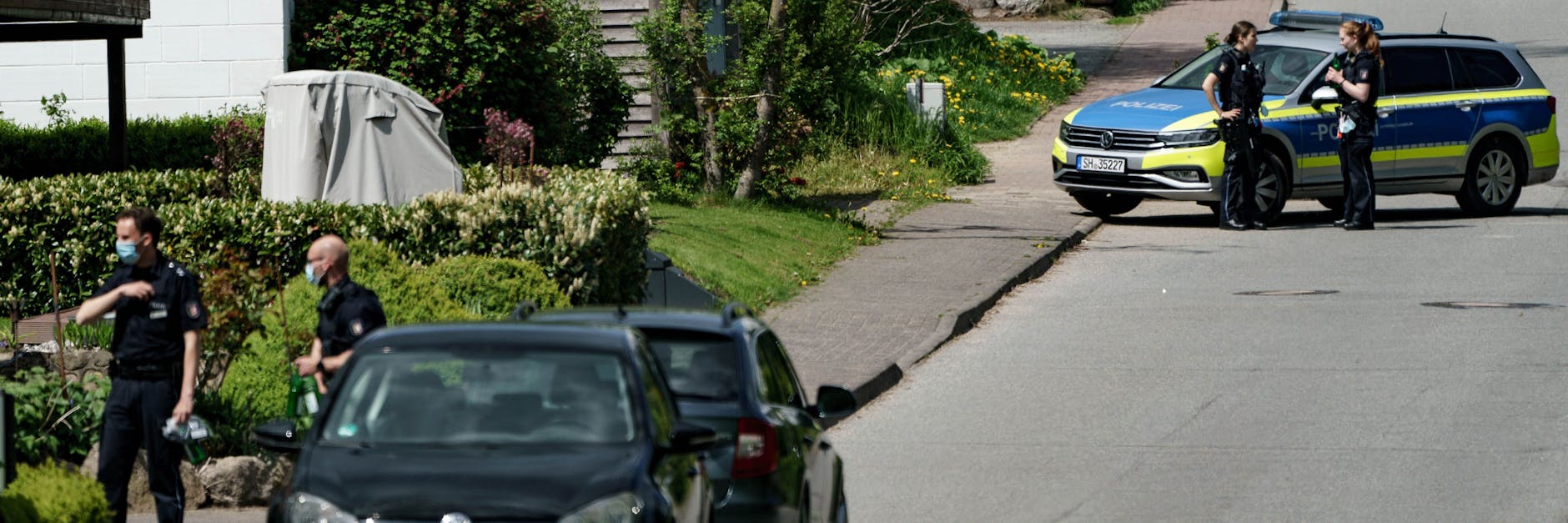 Einsatzkräfte der Polizei sperren in Dänischenhagen die Straße ab, in der die Schüsse gefallen sind. 