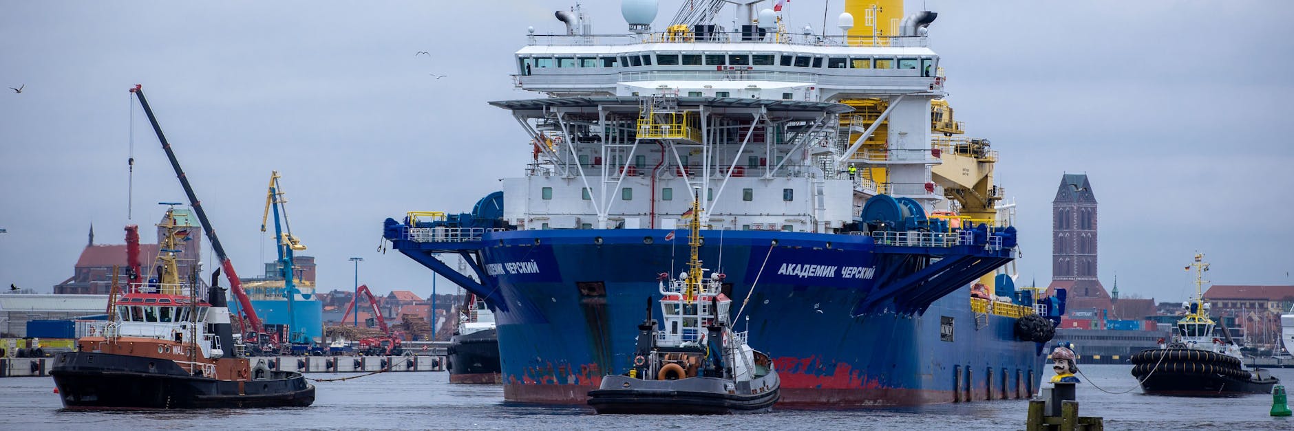 Schlepper ziehen das russische Rohr-Verlegeschiff „Akademik Tscherski“ aus dem Seehafen Richtung Ostsee.