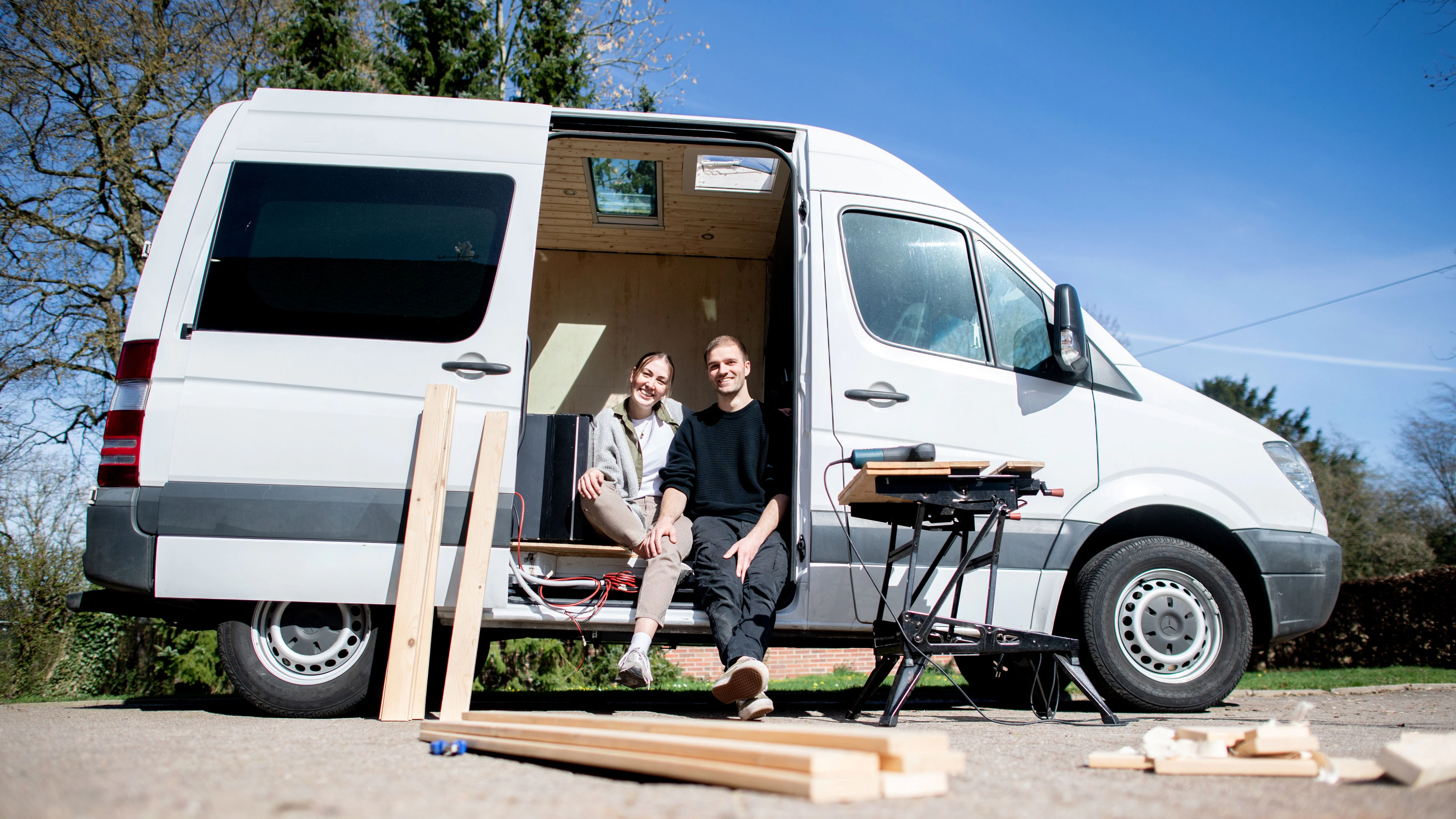 Greta Thomas und Hannes Wehrmann sitzen in ihrem Mercedes-Benz Sprinter, den das Paar in Eigenarbeit zu einem Campervan umbaut.&nbsp;