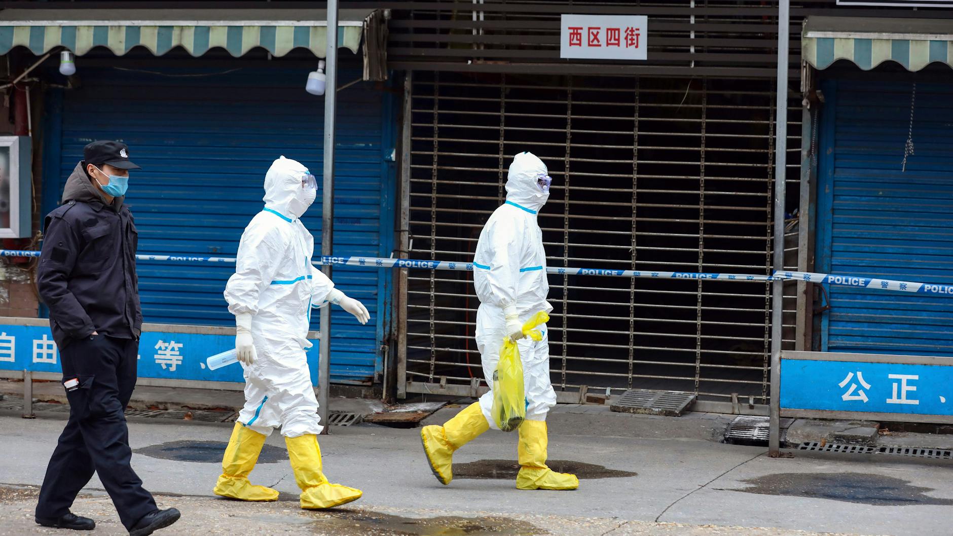 Arbeiter in Schutzkleidung tragen im Januar 2020 eine Tasche in der sich ein Riesensalamander befindet, der vom Wuhan Seafood Market entkommen sein soll.