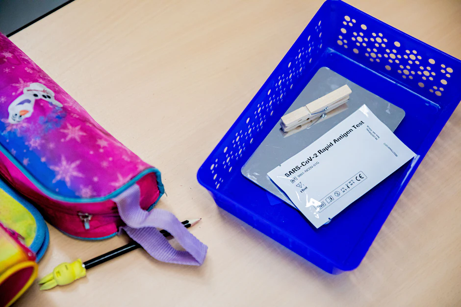 Ein Schnelltest neben einem Federmäppchen in einer Berliner Grundschule. Wird ein Schüler positiv getestet, muss manchmal die ganze Klasse in Quarantäne. Derzeit ist dies aufgrund Rückläufiger Zahlen immer seltener der Fall.