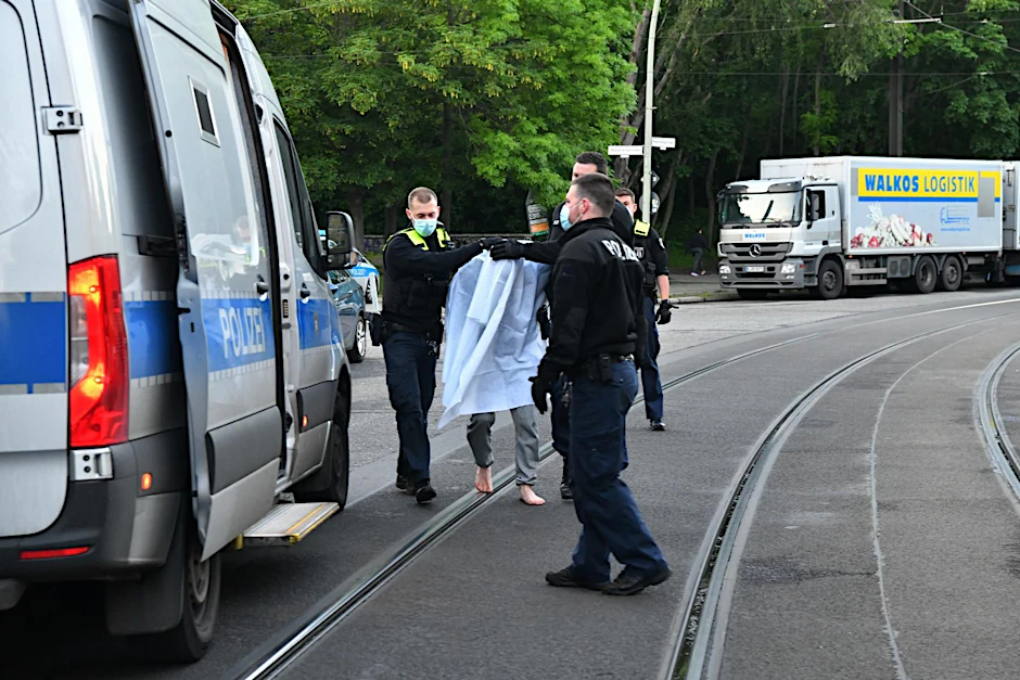 Messermord in der Oderbruchstraße. Die Polizei führt den Tatverdächtigen ab.