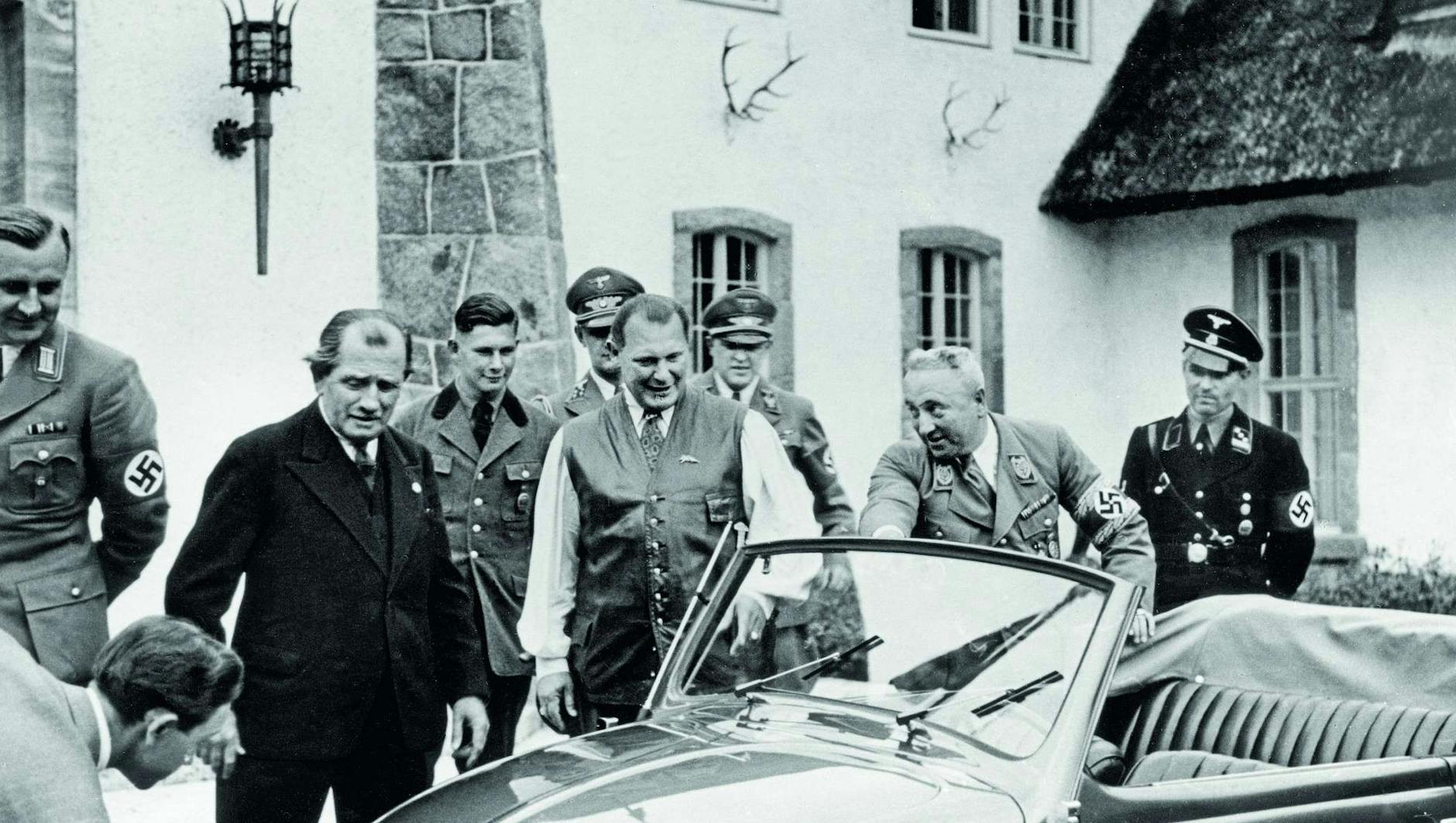 Auf Carinhall widmete sich Hermann Göring (Bildmitte) nicht nur der Jagd. Hier empfing er auch Größen aus Politik und Wirtschaft, wie Ferdinand Porsche (links, im Anzug), der ihm 1939 den neuen KdF-Wagen mit Faltdach vorführte.
