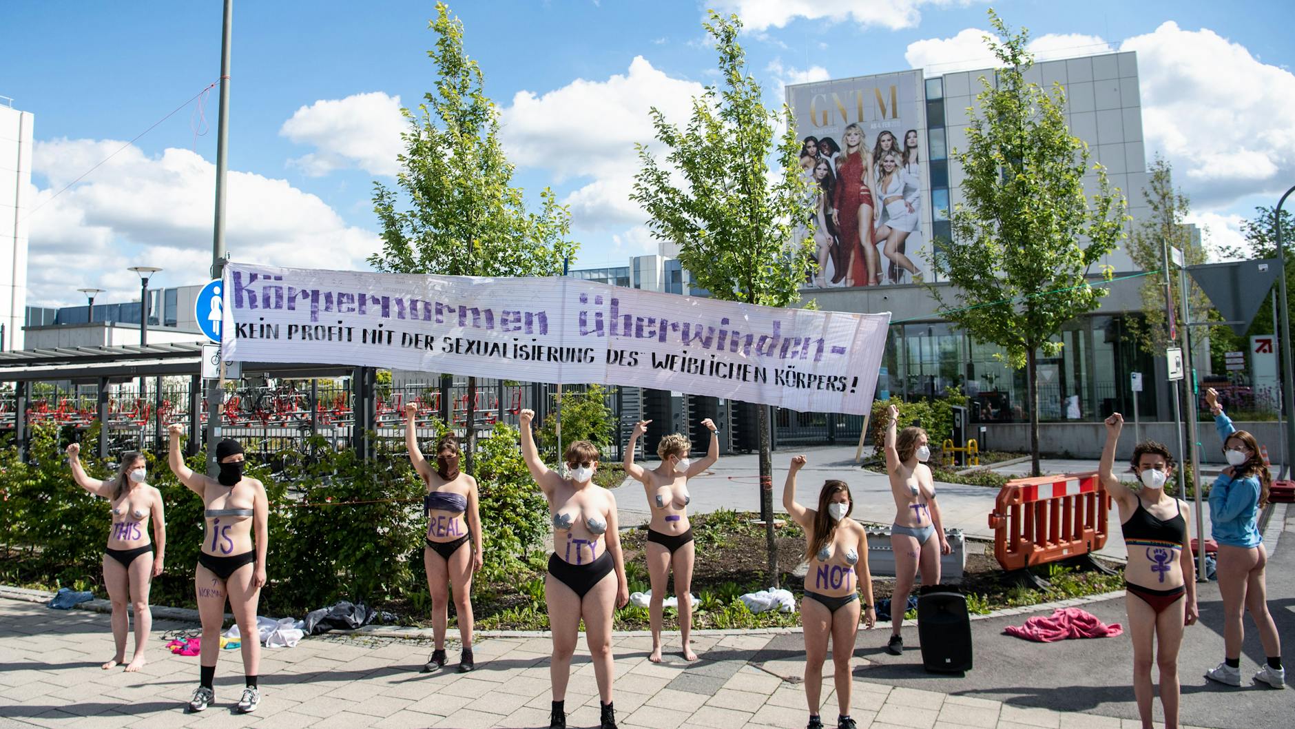 Mit Körperfarbe bemalte Aktivistinnen vom Augsburger Klimacamp demonstrieren vor einem Gebäude des Fernsehsenders ProSieben gegen die Fernsehshow Germany’s Next Topmodel.