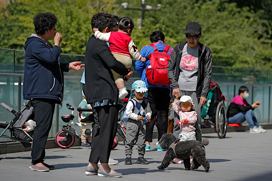 Anwohner in Peking bringen ihre Kinder zum Spielen auf ein Gelände in der Nähe eines kommerziellen Bürogebäudes.&nbsp;
