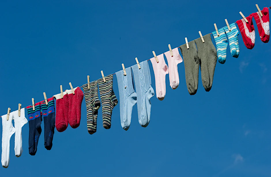 Noch fröhlich vereint: Paarweise hängen diese Socken auf der Leine – ein Wäschesack kann sie vor dem Verschwinden in der Waschmaschine bewahren, andernfalls droht ewige Socken-Vereinzelung.