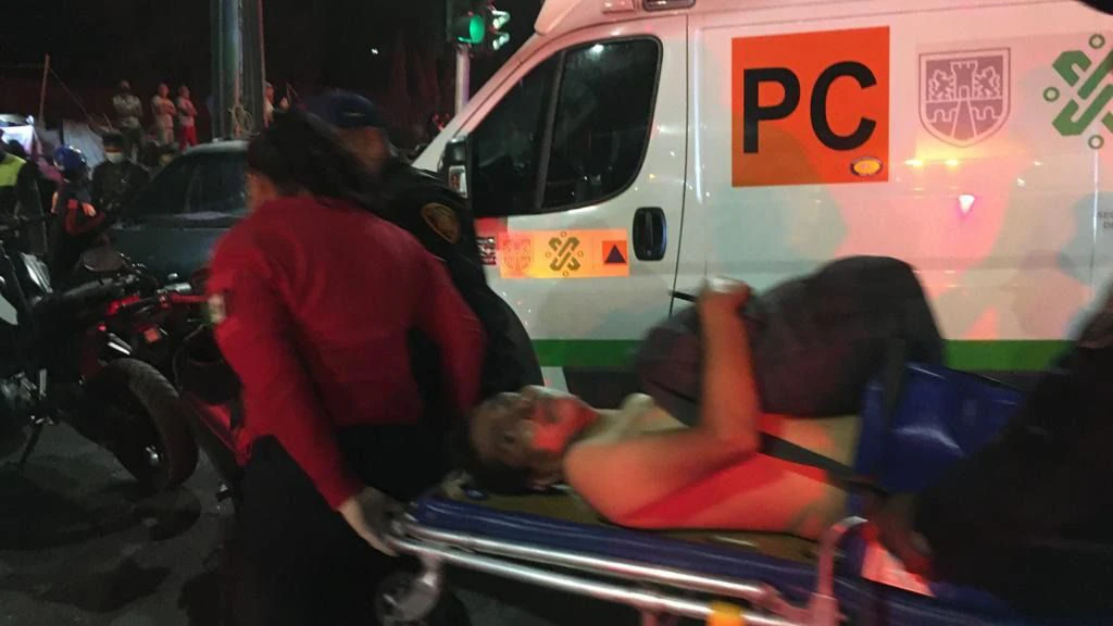 Rettungskräfte transportieren einen Verletzten auf einer Trage zu einem Krankenwagen.