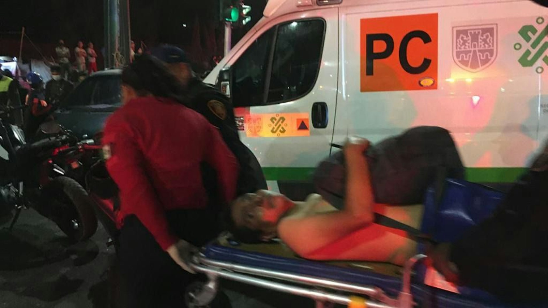 Rettungskräfte transportieren einen Verletzten auf einer Trage zu einem Krankenwagen.