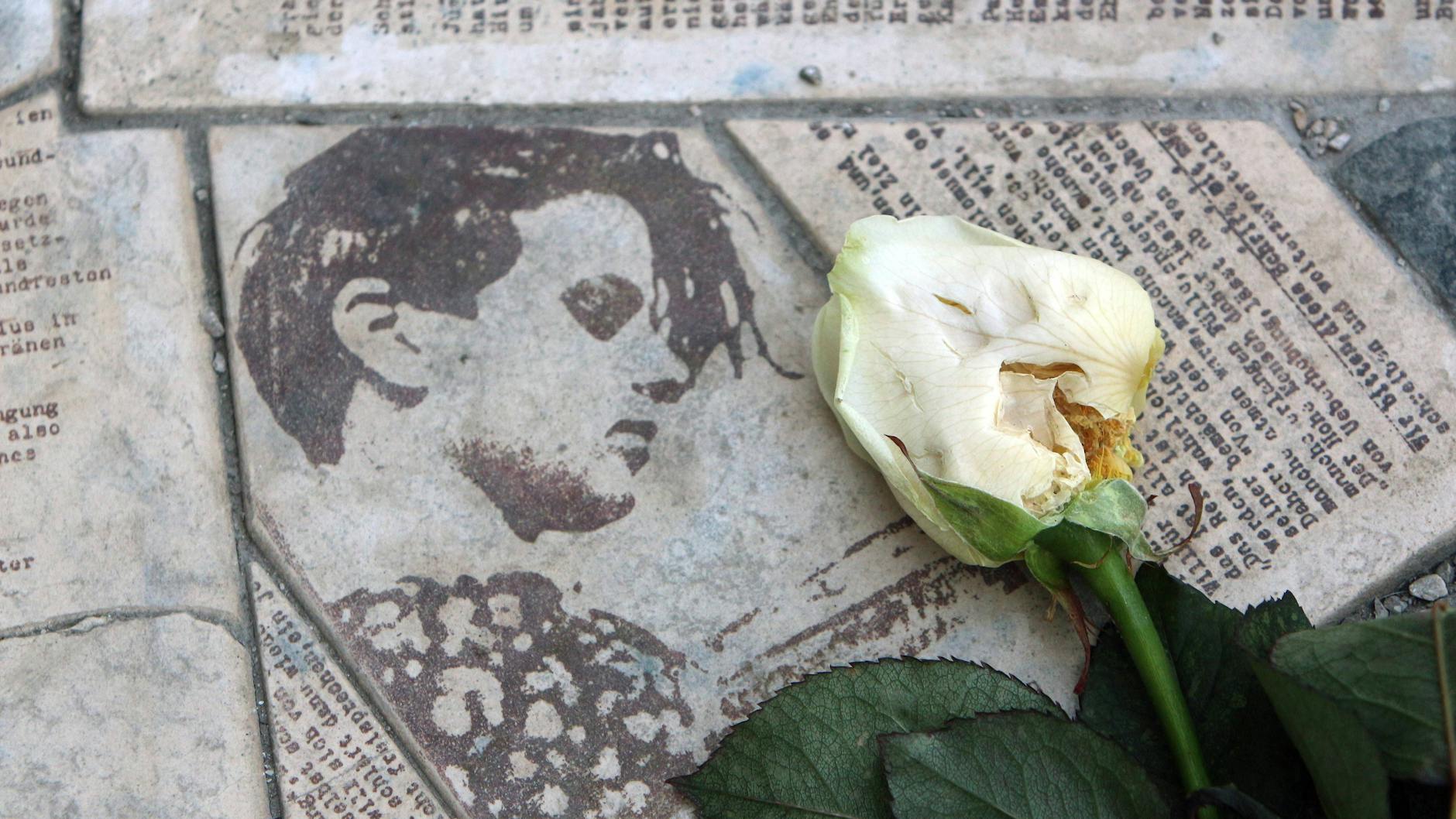 In das Pflaster eingelassene Flugblätter mit einem Porträt von Sophie Scholl bilden die Gedenkstätte Weiße Rose an der Ludwig-Maximilian-Universität in München.