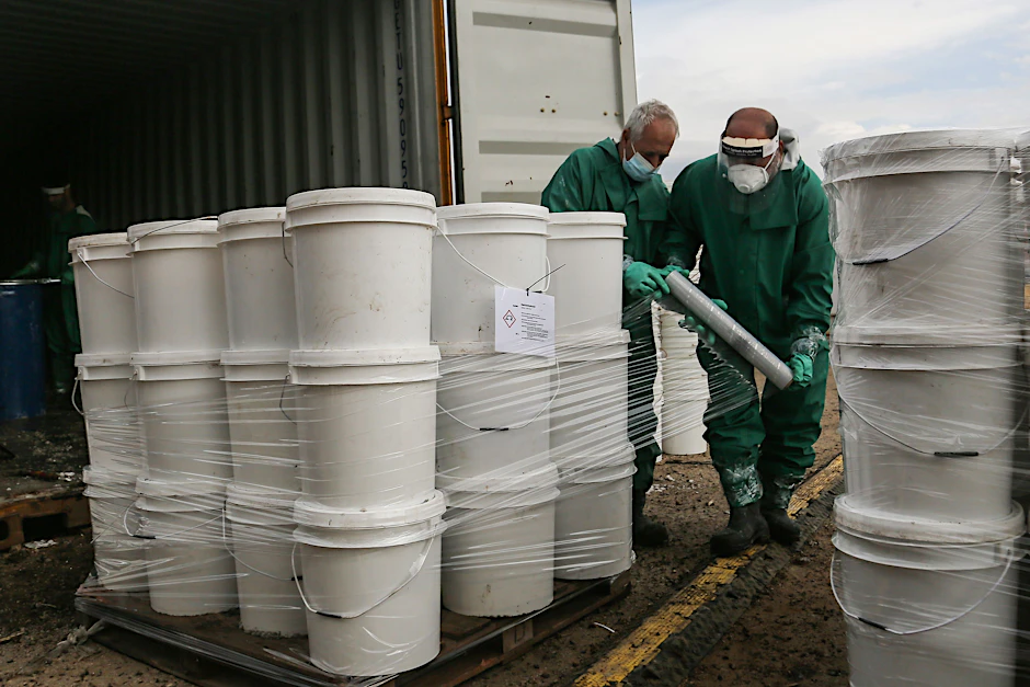 Beirut: Zwei Arbeiter verpacken giftige Chemikalien, die im zerstörten&nbsp;Hafen von Beirut aus Containern geborgen wurden. Jetzt wird das Zeug in Deutschland entsorgt.
