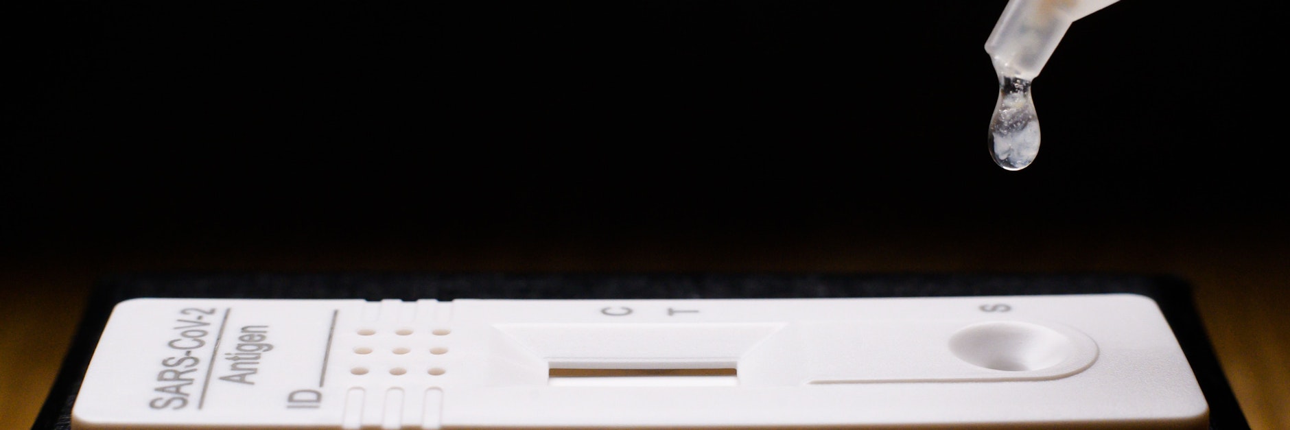Flüssigkeit wird auf einen Selbsttest für das Coronavirus getröpfelt.