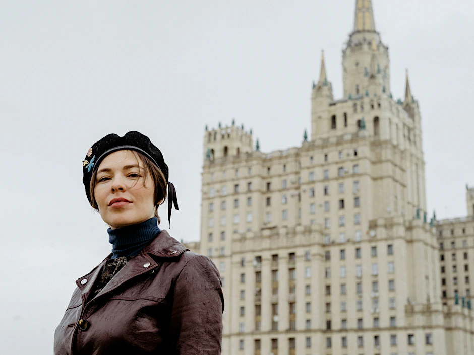 Musikerin und DJ Nina Kraviz über den Dächern von Moskau. Hinter ihr zu sehen ist ein Gebäude der „Sieben Schwestern.“