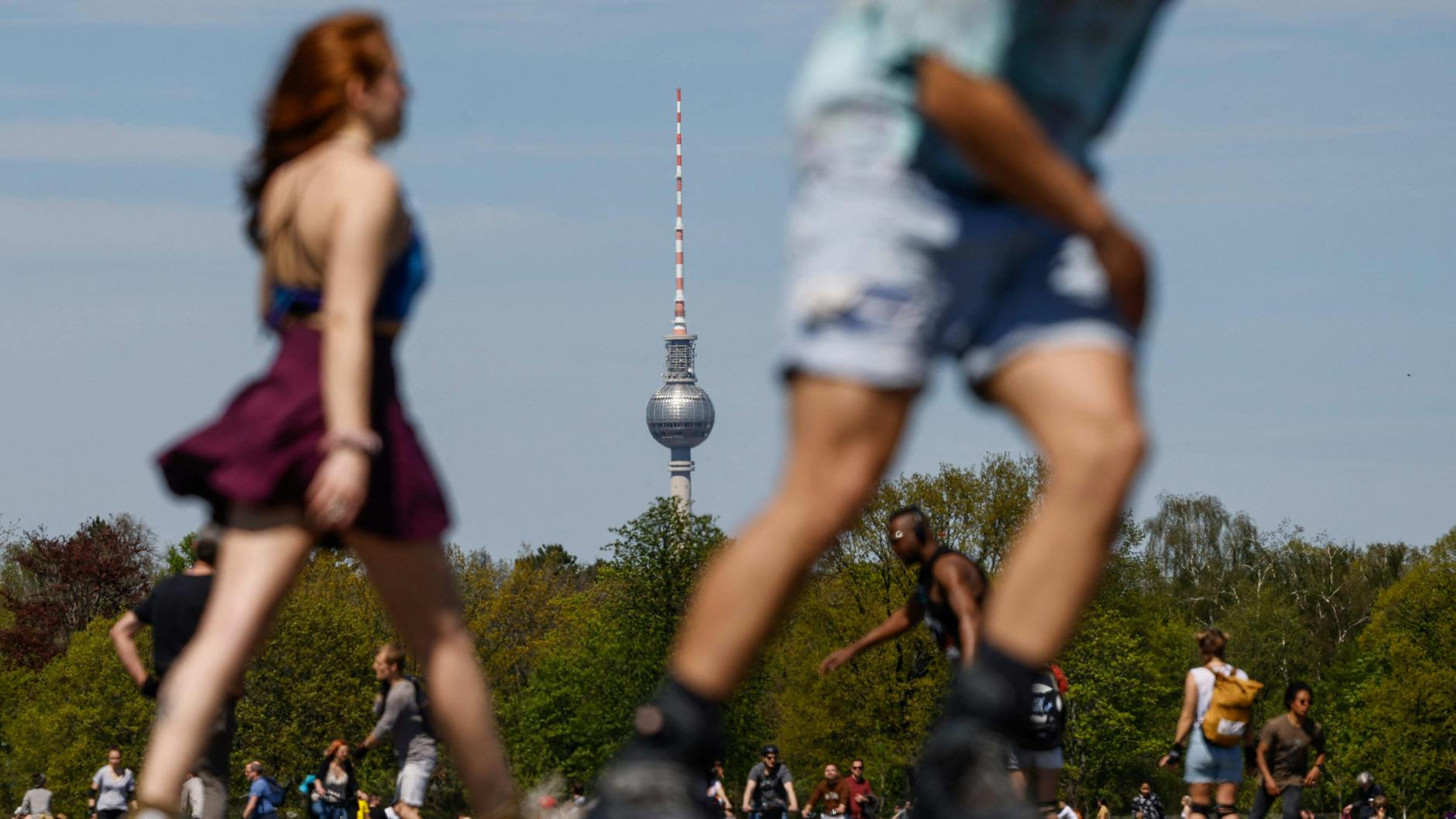Das Tempelhofer Feld in Berlin: Spaziergänger und Skater sind unterwegs - und auch die Kleidung wird luftiger.