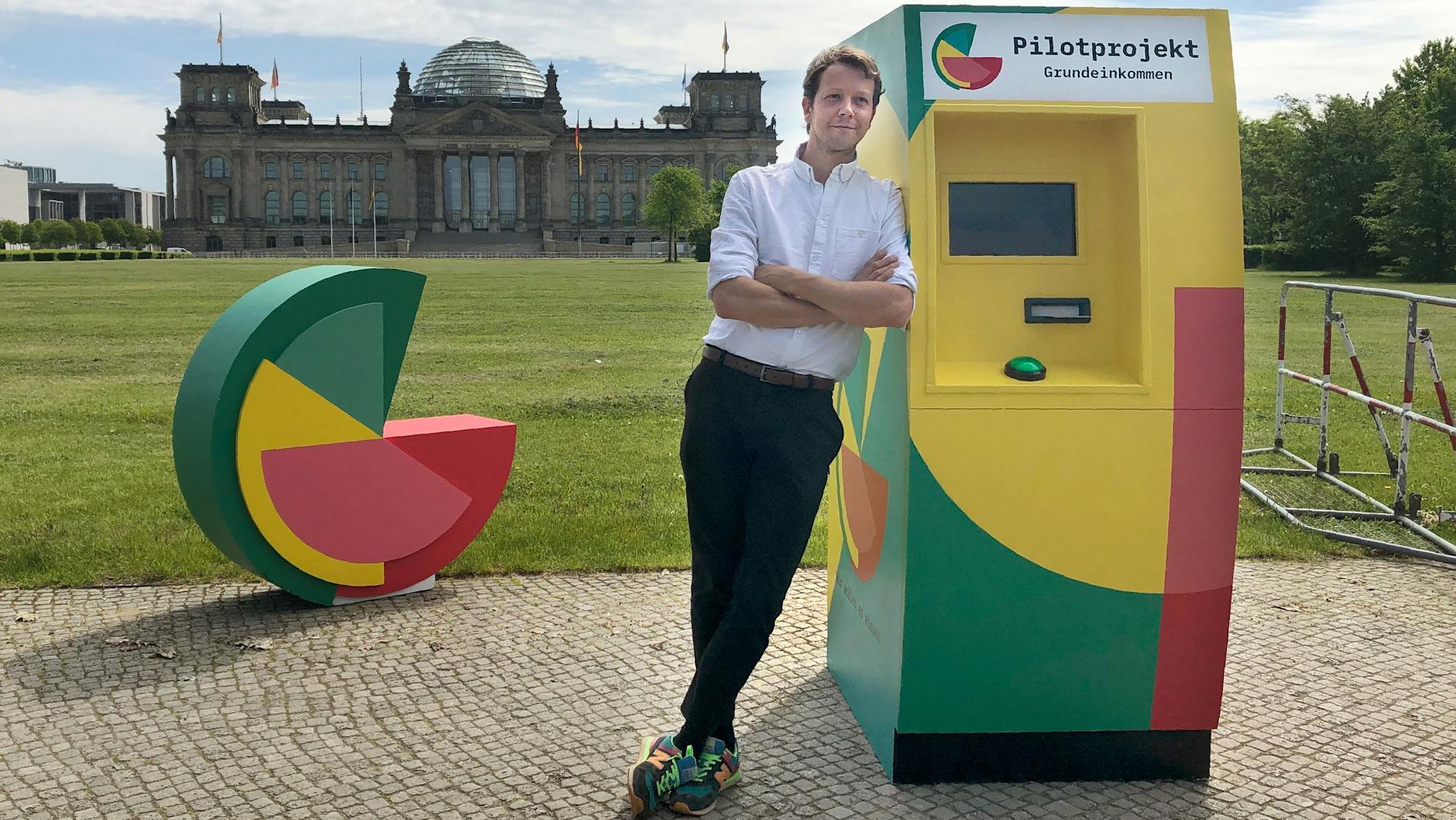 Michael Blohmeyer, Initiator des Vereins „Mein Grundeinkommen“, steht an einem symbolischen Geldautomaten.