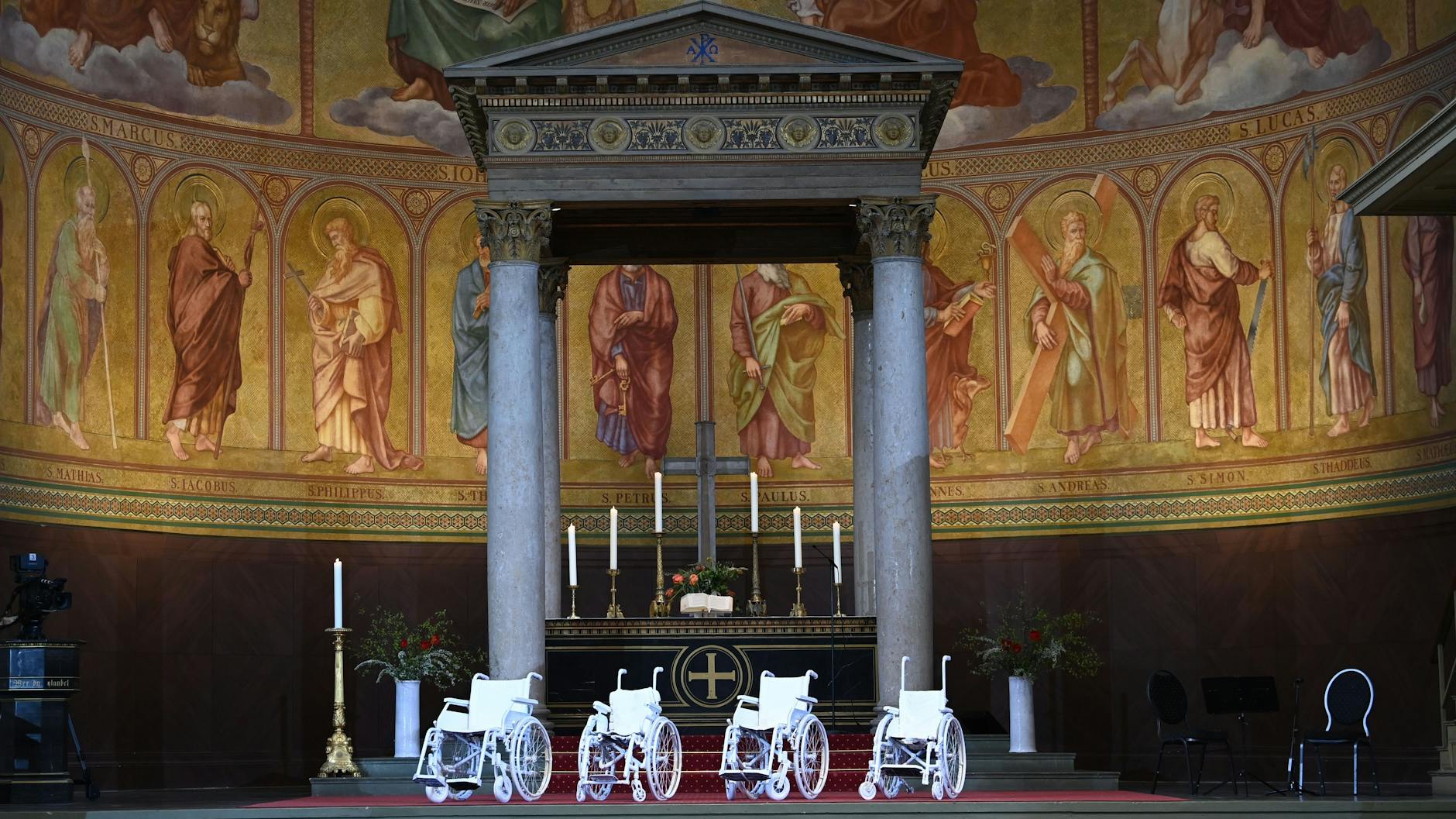 Vier weiße Rollstühle stehen vor Beginn des Gedenkgottesdienstes für die getöteten Bewohner des Oberlinhauses im Altarbereich der Nikolaikirche.