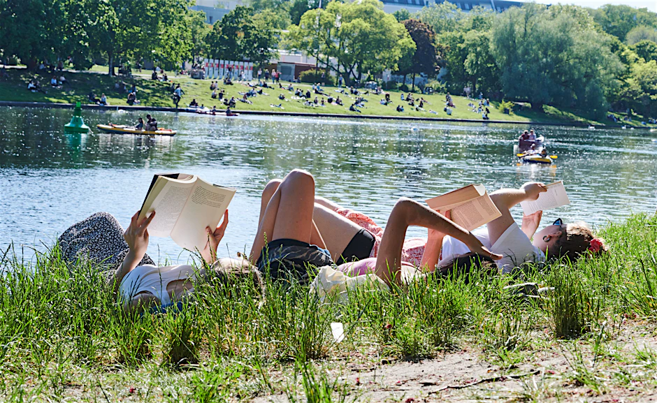 Drei Frauen liegen auf der Wiese am Landwehrkanal und lesen Bücher. Der Sommer ist in Berlin angekommen, Corona geht (Archivbild).&nbsp;&nbsp;