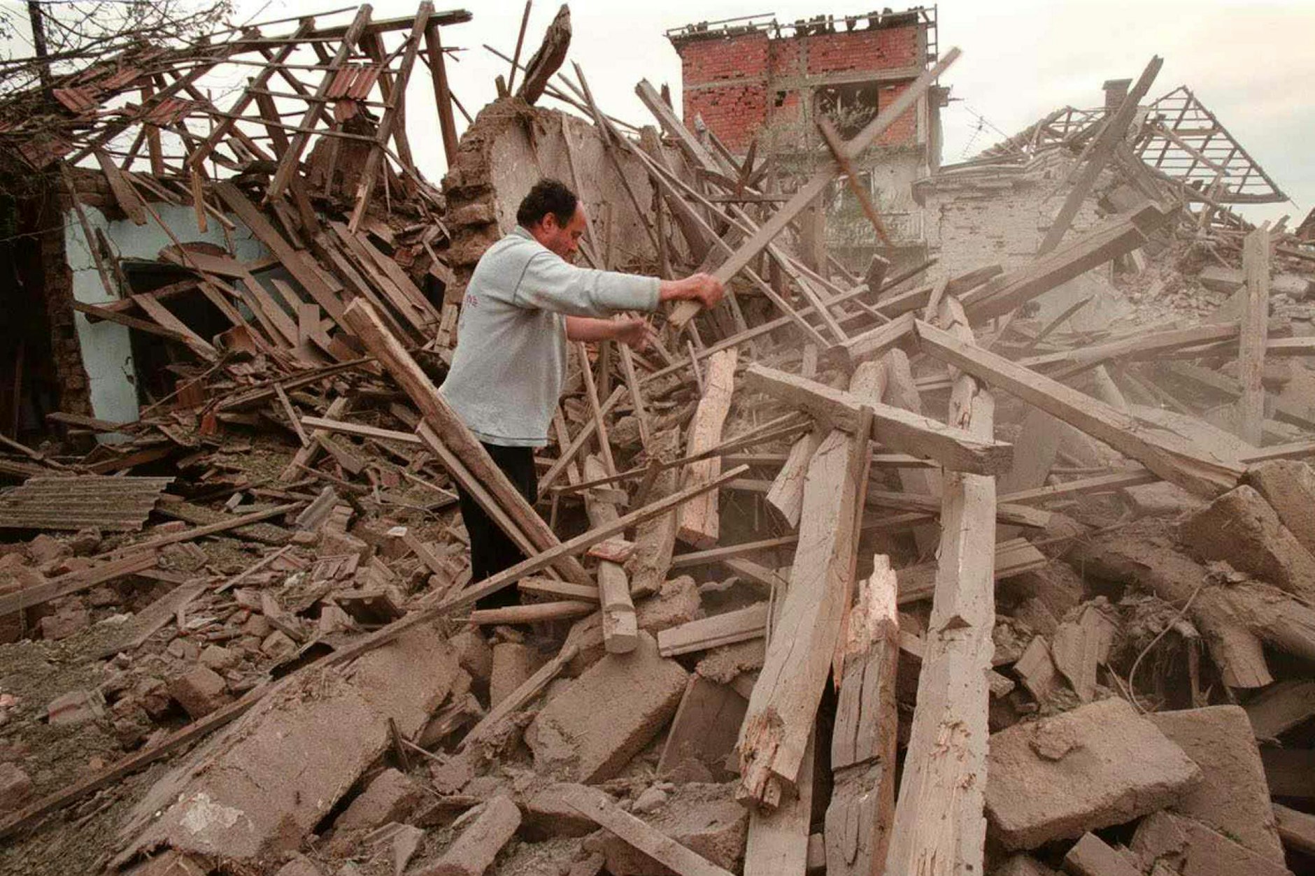 Ein Mann in den Ruinen seines Hauses nach einem Nato-Angriff am 7. Mai 1999 auf Nis, rund 230 Kilometer von Belgrad entfernt. Mindestens 15 Personen wurden damals getötet. Ziel war offenbar ein Industriegebiet außerhalb der Stadt, aber auch auf den Stadtrand fielen Bomben.