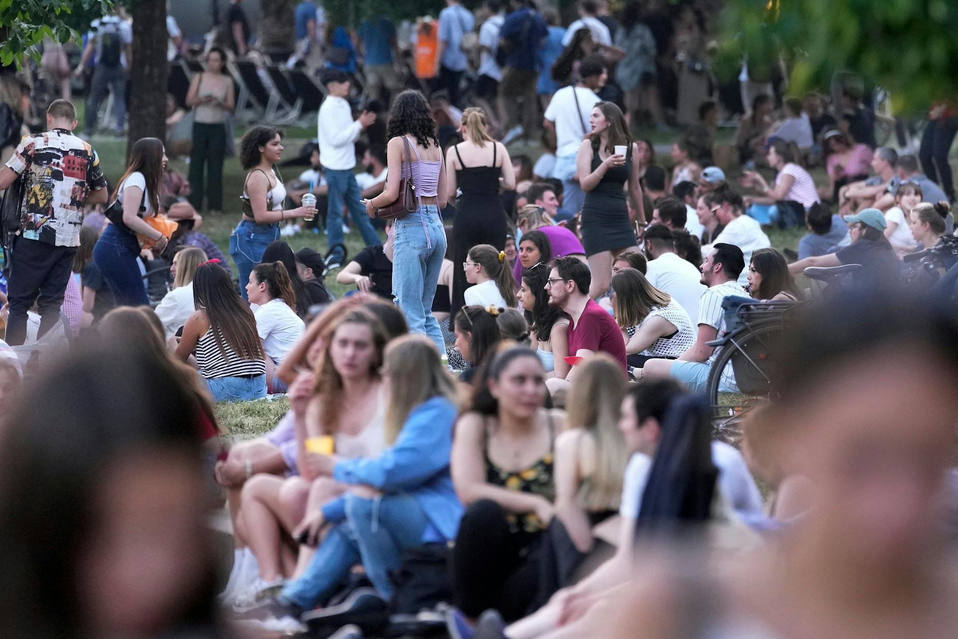 Berliner genießen einen warmen Sommerabend im Monbijoupark.