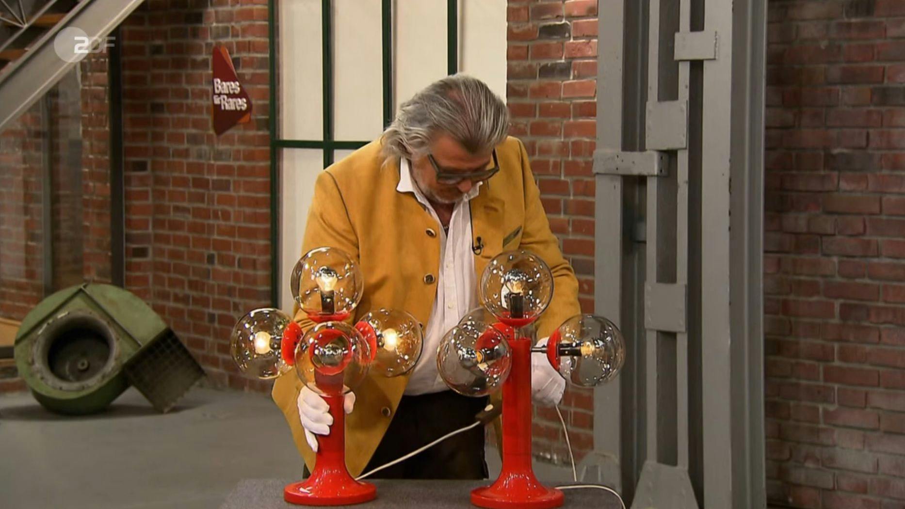 „Bares für Rares“-Händler Roman Runkel nimmt die DDR-Lampen unter die Lupe, hat aber beim Bietergefecht kein Interesse an den alten Teilen.