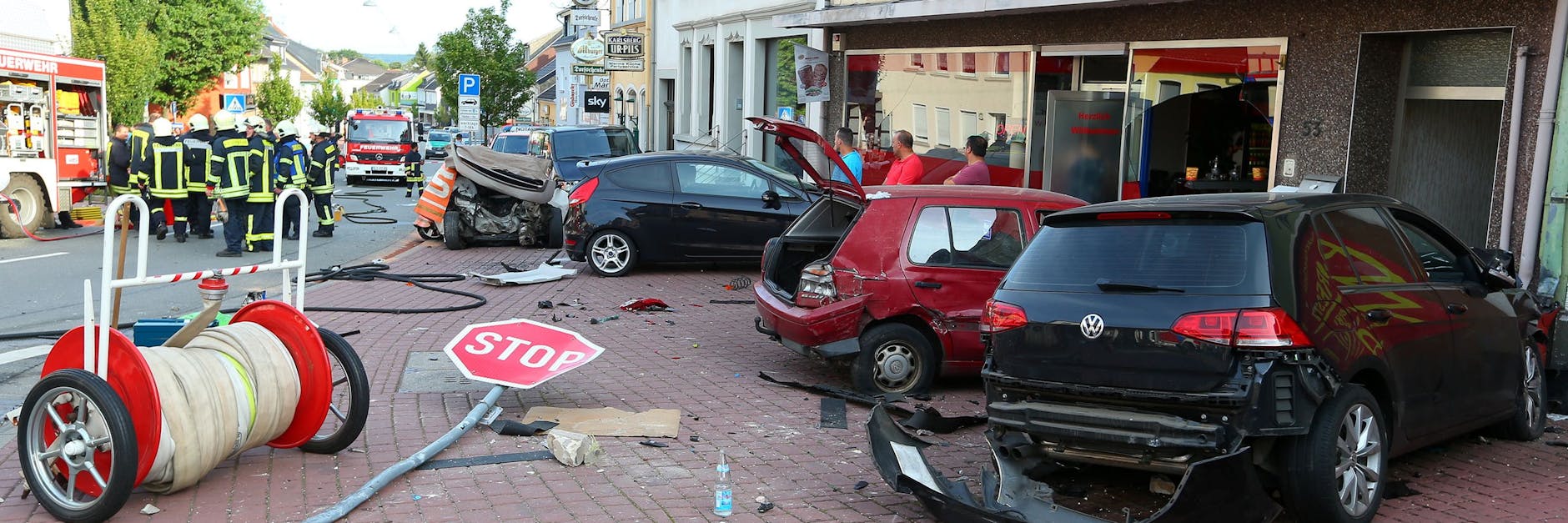 Ein Bild der Verwüstung bietet sich, nachdem ein Autofahrer ungebremst gegen einen Wagen (links hinten neben der Gruppe von Feuerwehrleuten) raste, in dem eine Frau und ein zwölfjähriges Kind dabei tödlich verletzt wurden.