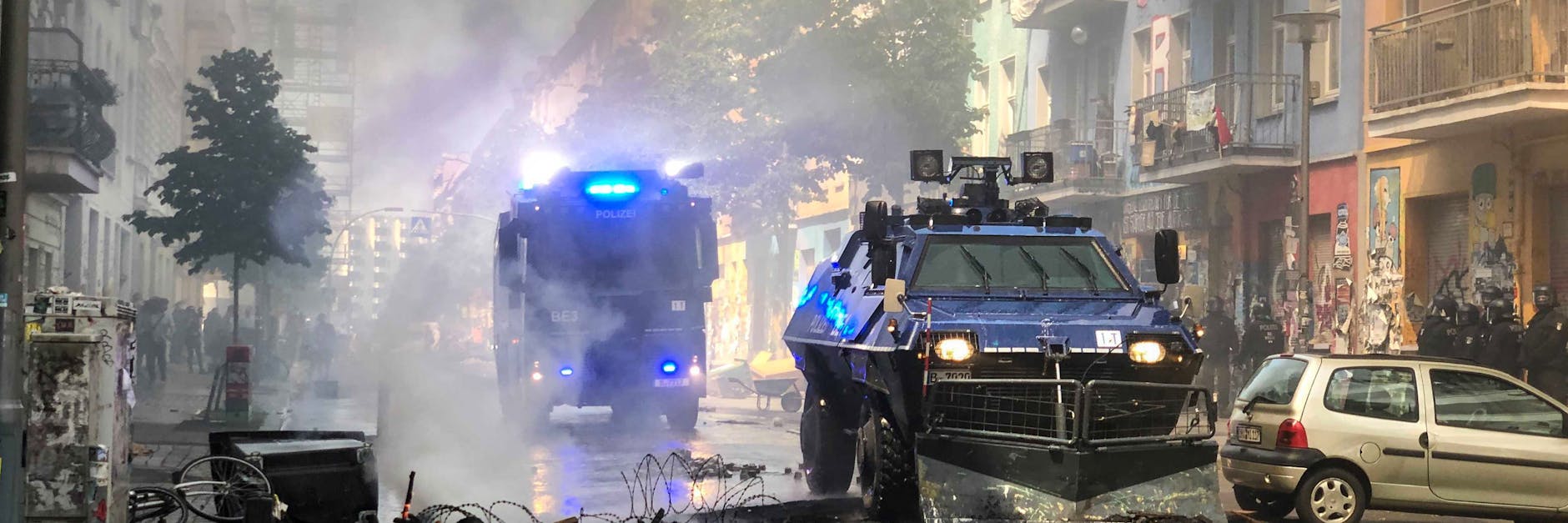 Räumpanzer und ein Wasserwerfer der Polizei fahren durch die Rigaer Straße in Berlin-Friedrichshain.