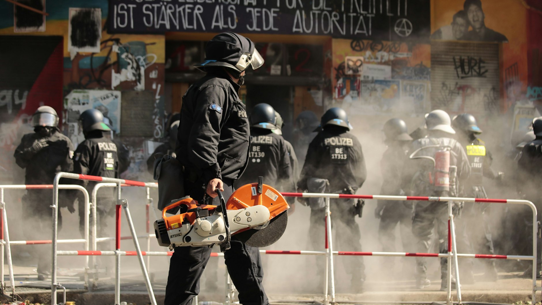 Mit Trennschleifern und Sägen: Polizisten öffnen die Tür des teilbesetzten Hauses Rigaer Straße 94.