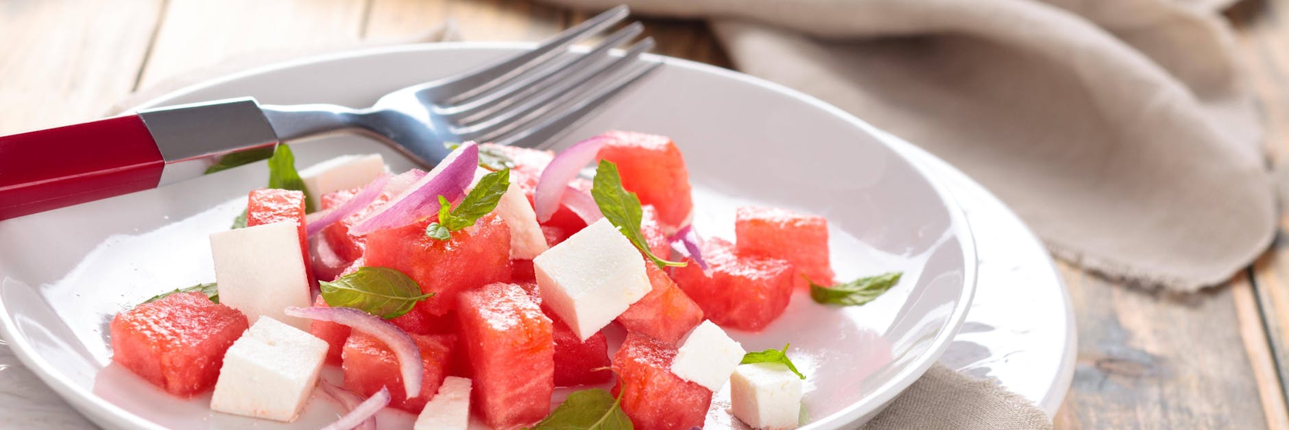 Der frische Melonensalat mit Fetakäse kann je nach Geschmack auch noch mit Minzblättchen verziert werden.