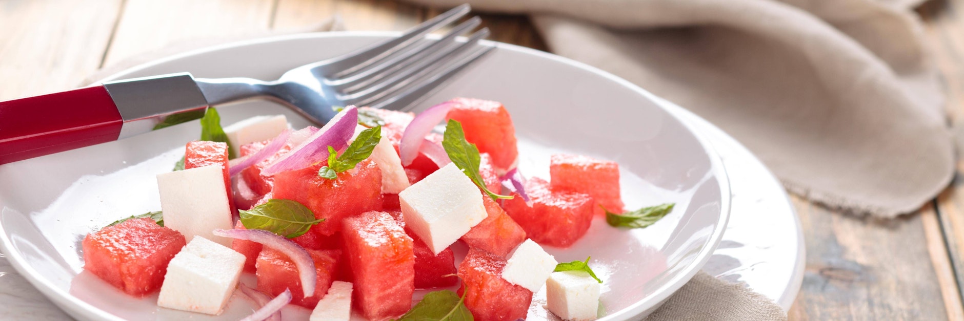 Der frische Melonensalat mit Fetakäse kann je nach Geschmack auch noch mit Minzblättchen verziert werden.