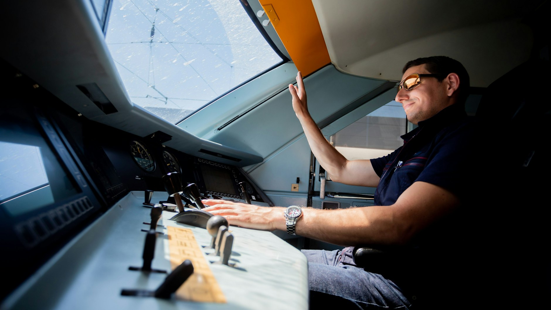 Kevin Tinney, Ausbilder für Lokführer bei der Deutschen Bahn, hebt die Hand, als er einen ICE 2 ins ICE-Werk Rummelsburg fährt.
