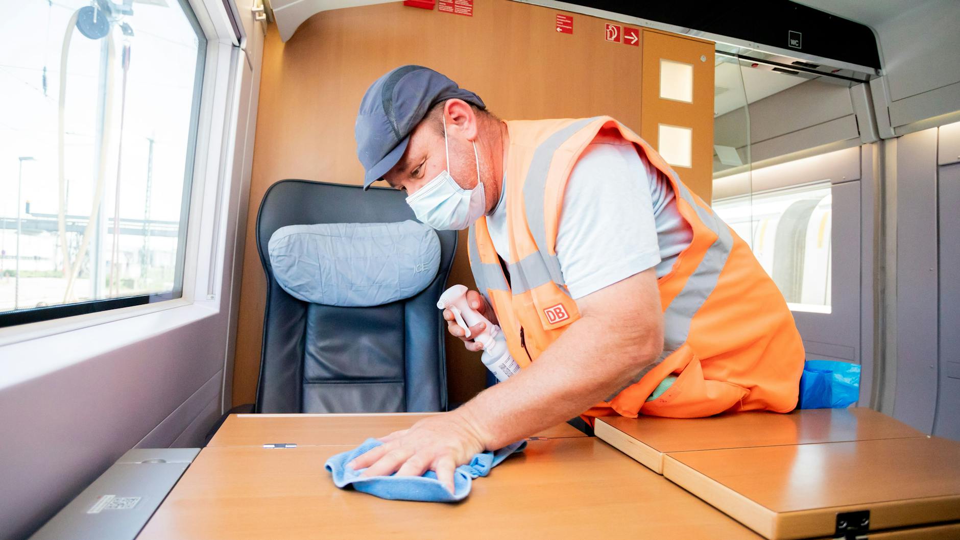 Marcel Ballin, Schichtleiter für die Fahrzeugreinigung, reinigt in einem ICE einen Tisch, als dieser im ICE-Werk Rummelsburg zur Reinigung Zwischenhalt macht