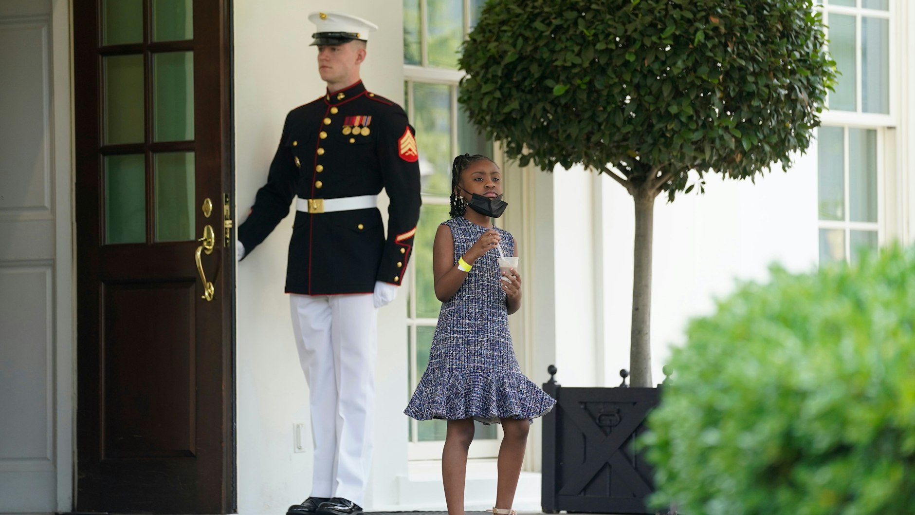 A guard holds the door as Gianna Floyd, the daughter of George Floyd, walks out of the West Wing of the White House in May.