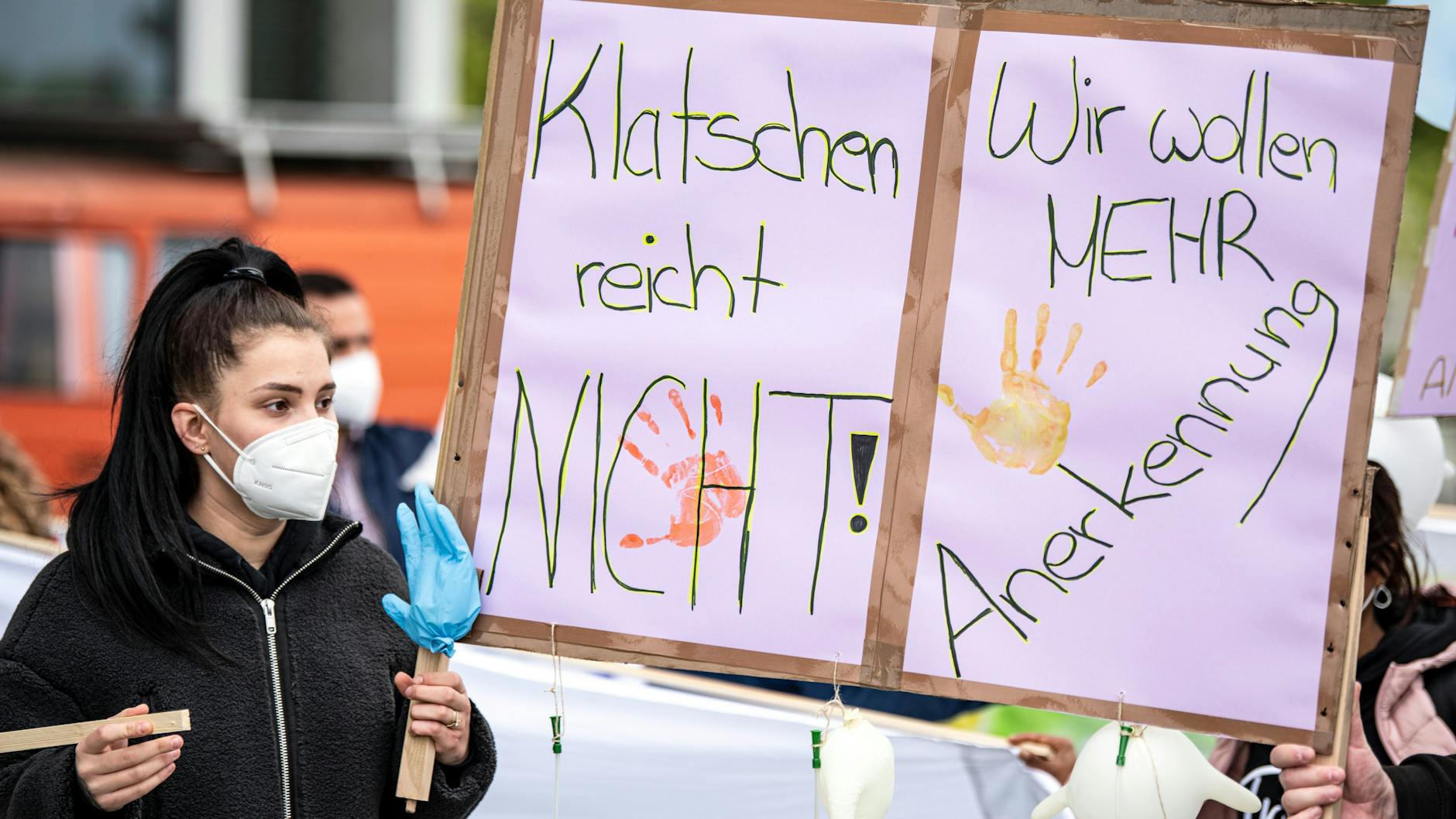 Eine Frau hält bei der Aktion „Der Pflege geht die Luft aus“ ein Plakat mit der Aufschrift „Klatschen reicht nicht“ hoch. 