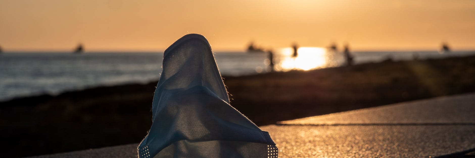 Eine Maske auf der Promenade erinnert daran, dass die Corona-Pandemie trotz niedriger Infektionszahlen noch nicht vorbei ist. 
