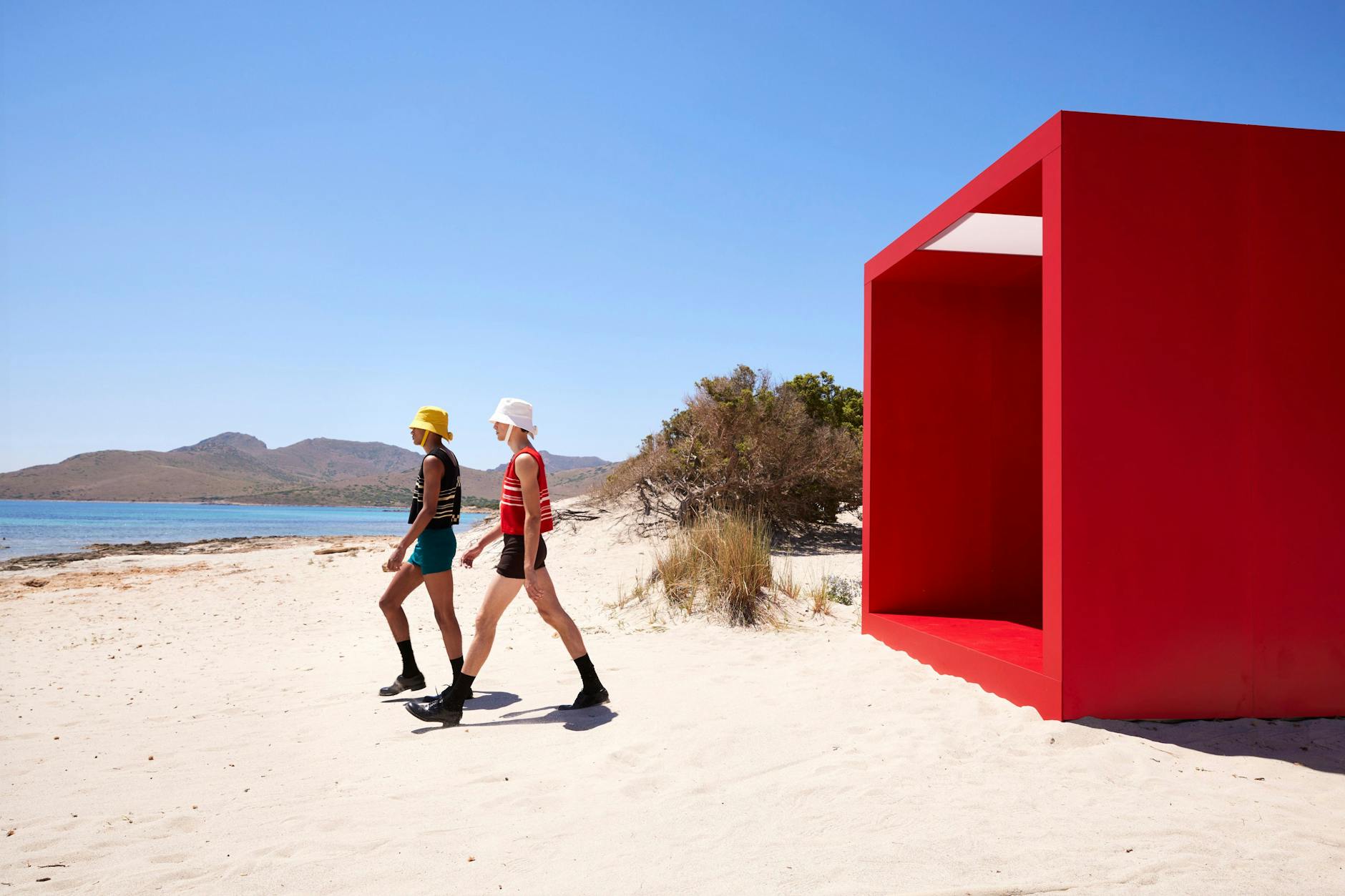 Das Prada-Outfit für den Schritt in die Freiheit sieht so aus: Anglerhut, Badehose, gestreiftes Tanktop, Strümpfe und Lederschuhe.