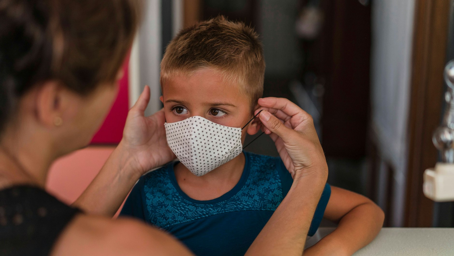 Ein kleiner Junge muss eine Maske anziehen.