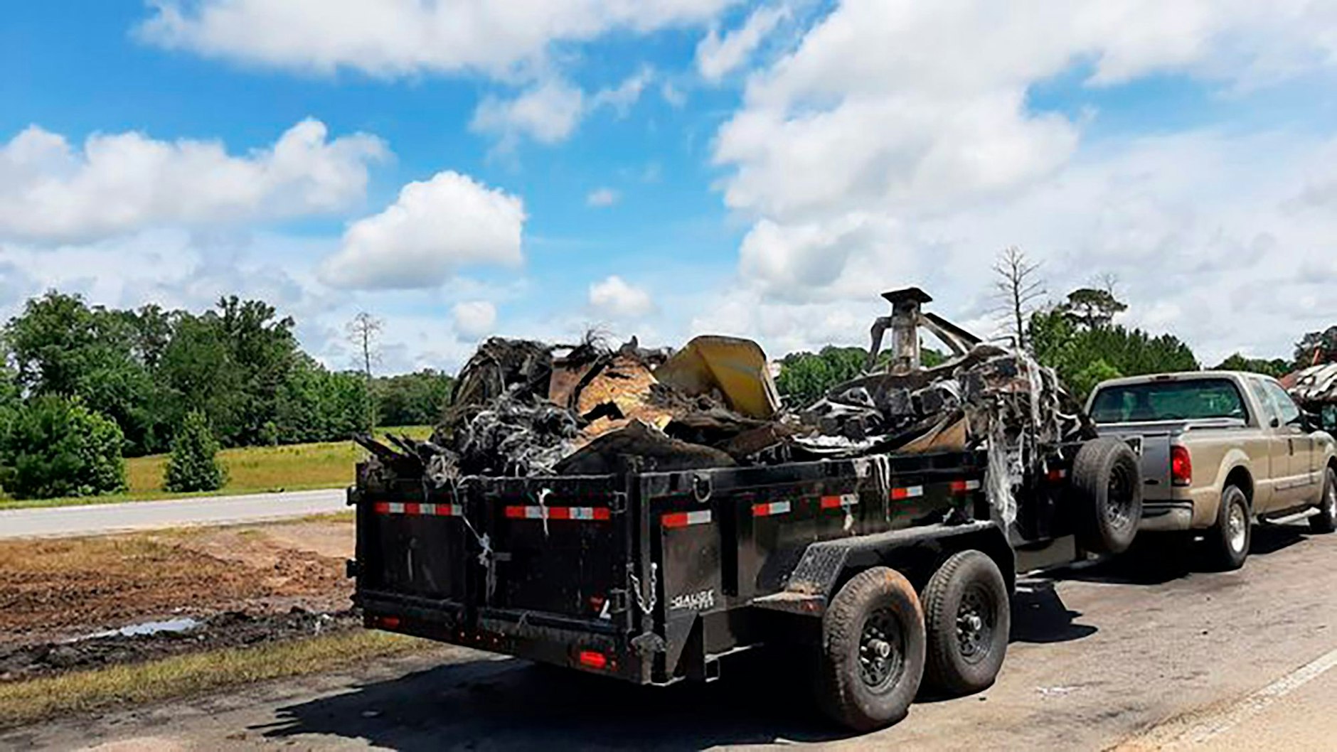 Fahrzeuge transportieren die durch die Flammen völlig zerstörten Unfall-Wracks ab.