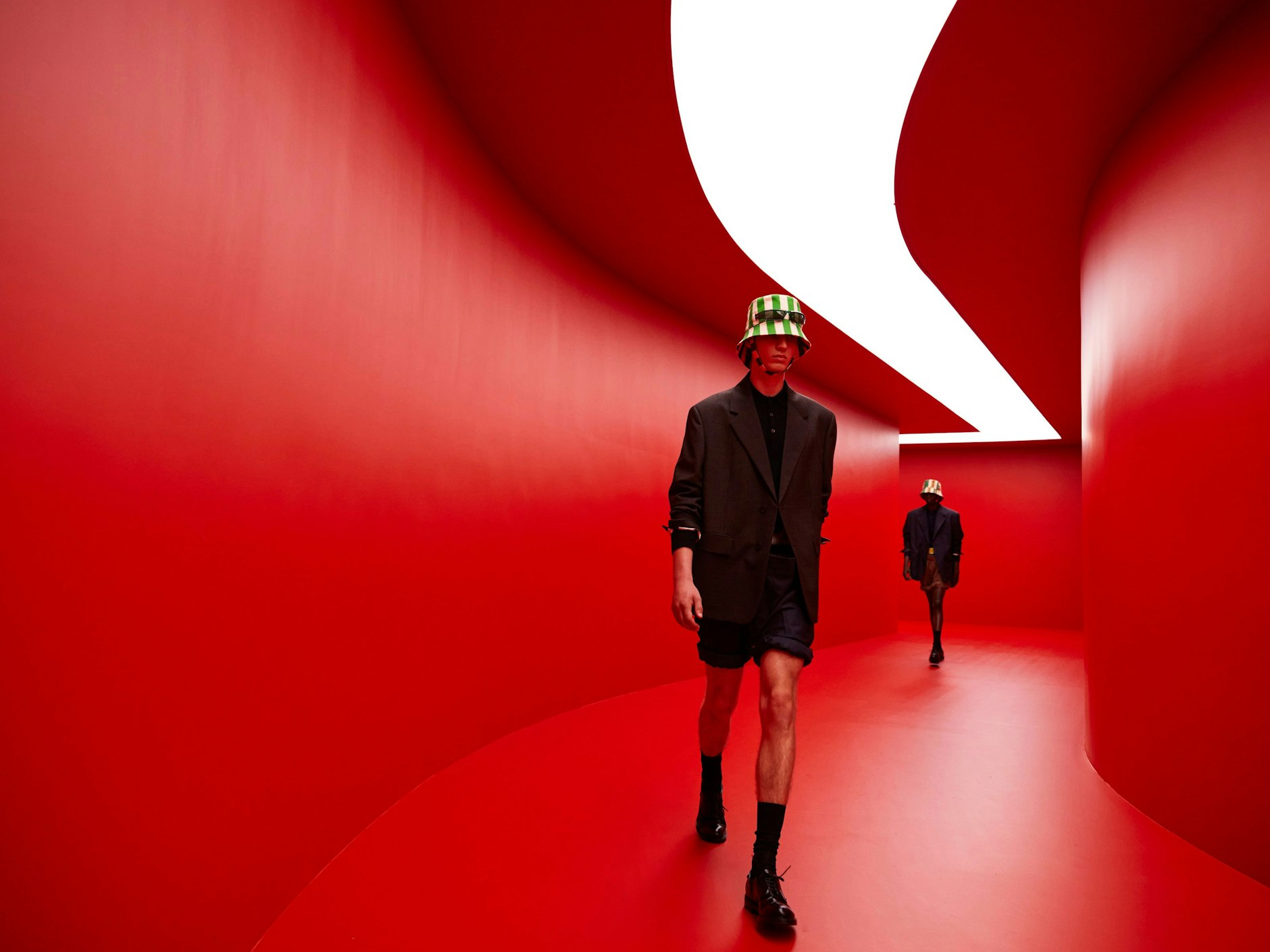 Rem Koolhaas designed the red catwalk tunnel for Prada's SS 2022 menswear collection. The tunnel was built at the Fondazione Prada and reconstructed on a Sardinian beach for the second part of the video-presentation.&nbsp;