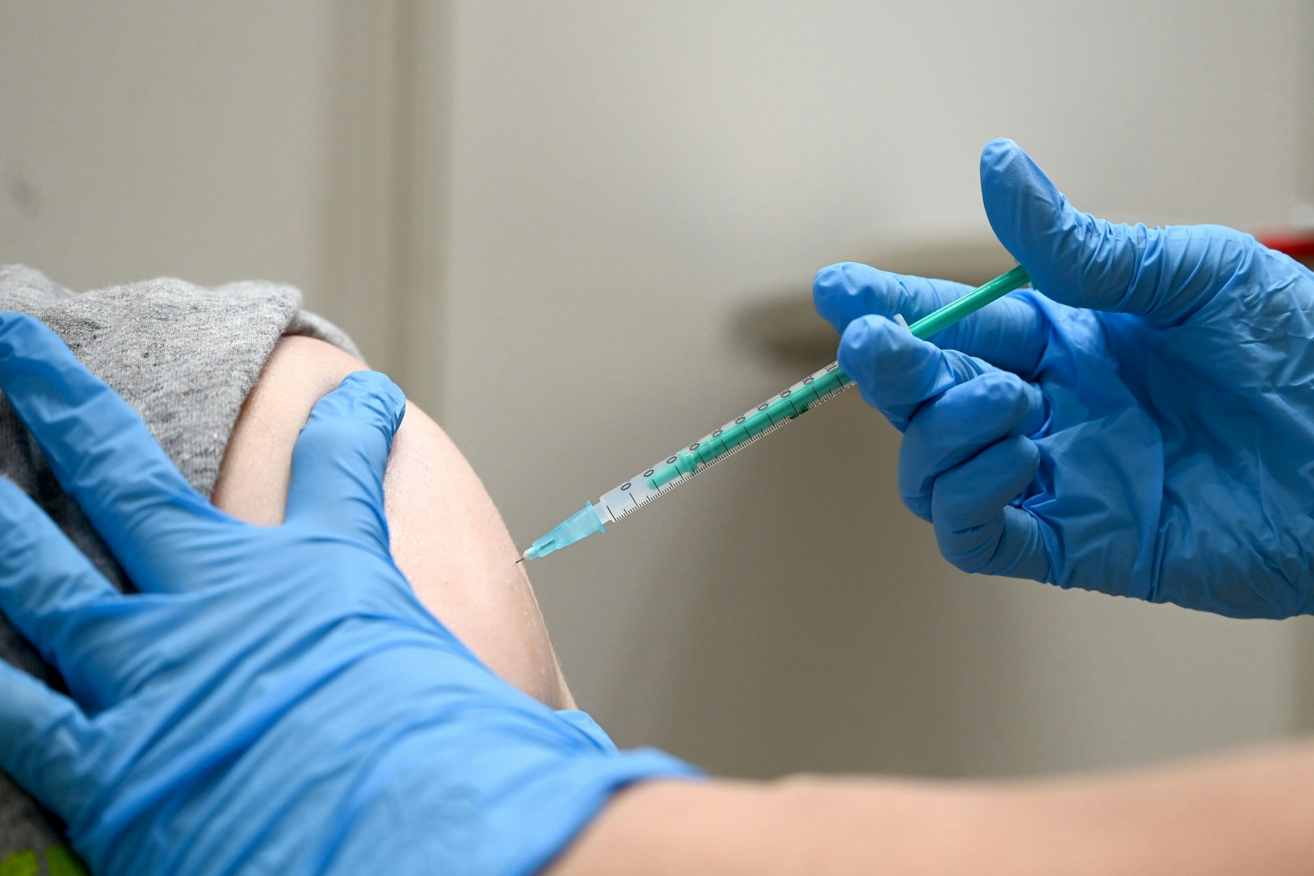 Eine Ärztin impft einen Mann mit einem Corona Impfstoff.