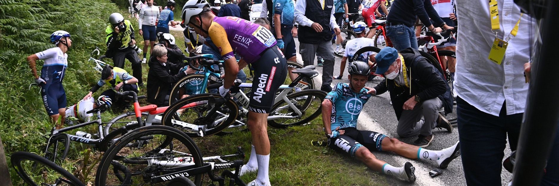 Mehrere Fahrer liegen nach dem Massensturz während der ersten Etappe der Tour de France verletzt am Straßenrand.