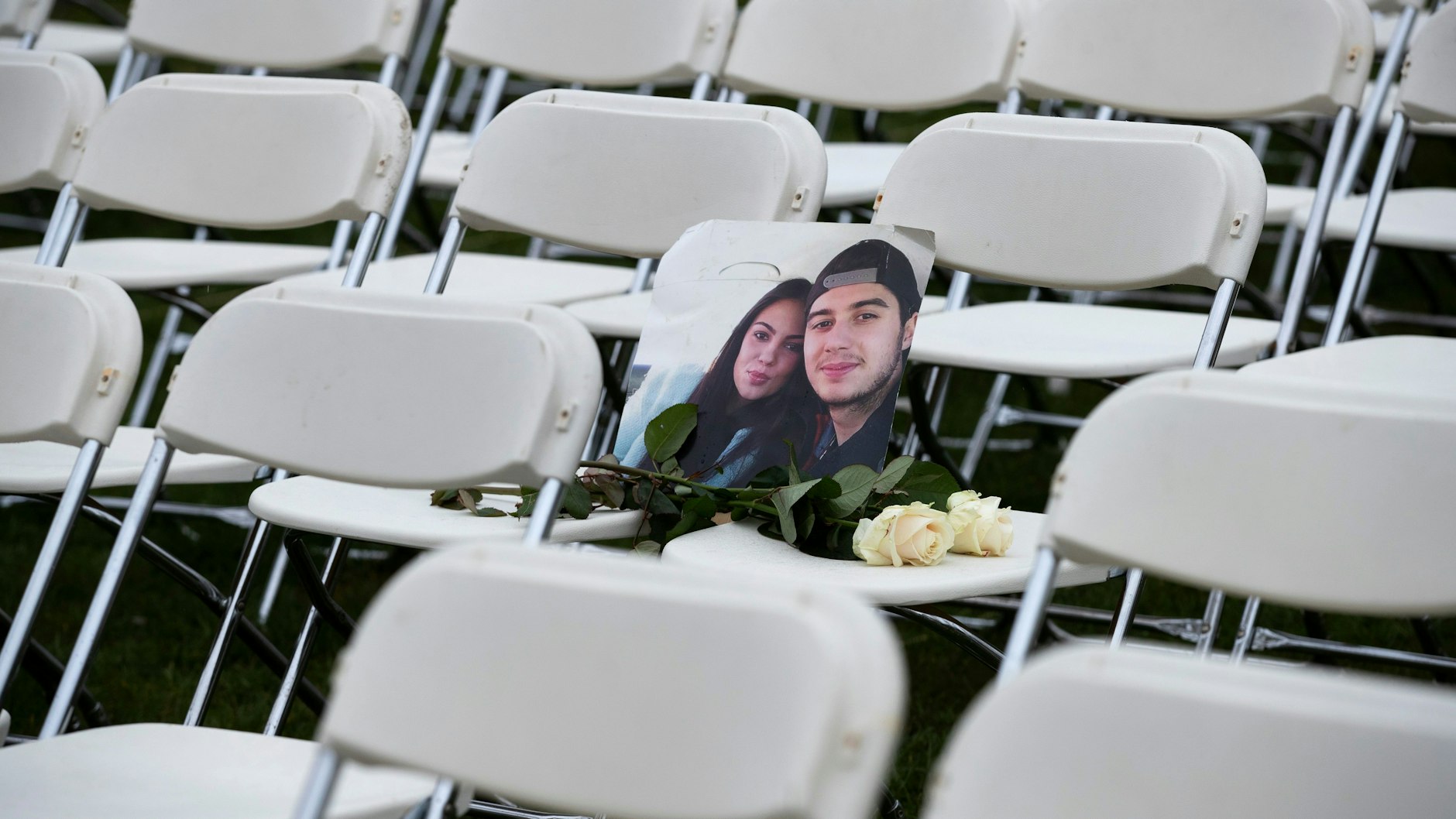 Ein Foto von Bryce Fredriksz und seiner Freundin Daisy lehnt zwischen zweien der 298 Stühle, die vor der russischen Botschaft in Den Haag aufgestellt wurden. Das Paar starb beim Abschuss von MH17.