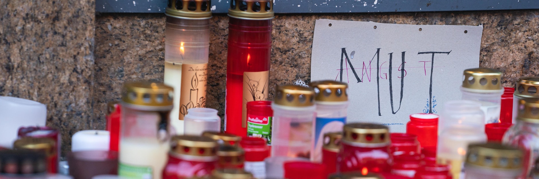 Inmitten des Kerzenmeers in Würzburg steht ein Schild mit der Aufschrift Mut. Diesen haben die Helfer bewiesen.