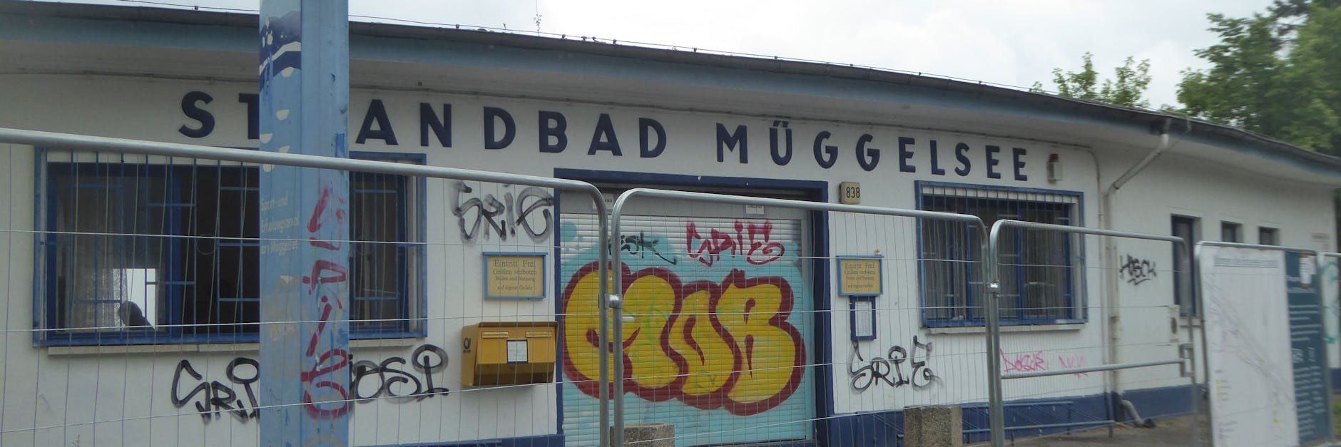 Das Hauptgebäude mit Haupteingang vom Strandbad Müggelsee: mit einem Bauzaun seit Tagen abgesperrt. Im Juli beginnen die Sanierungsarbeiten.