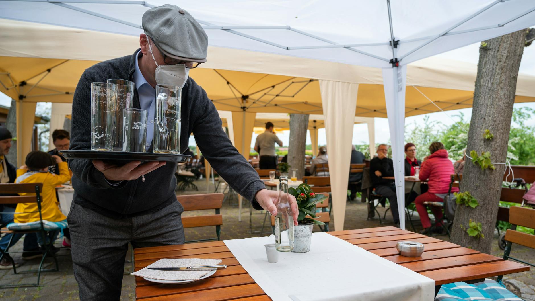 Wirt Mario Kade räumt auf der Terrasse seines „Restaurants am Pfingstberg“ einen Tisch ab. Die anhaltende Corona-Testpflicht stellt viele seiner Kollegen vor die Frage: Mache ich jetzt auf oder nicht? Denn noch immer kommen wenig Gäste.