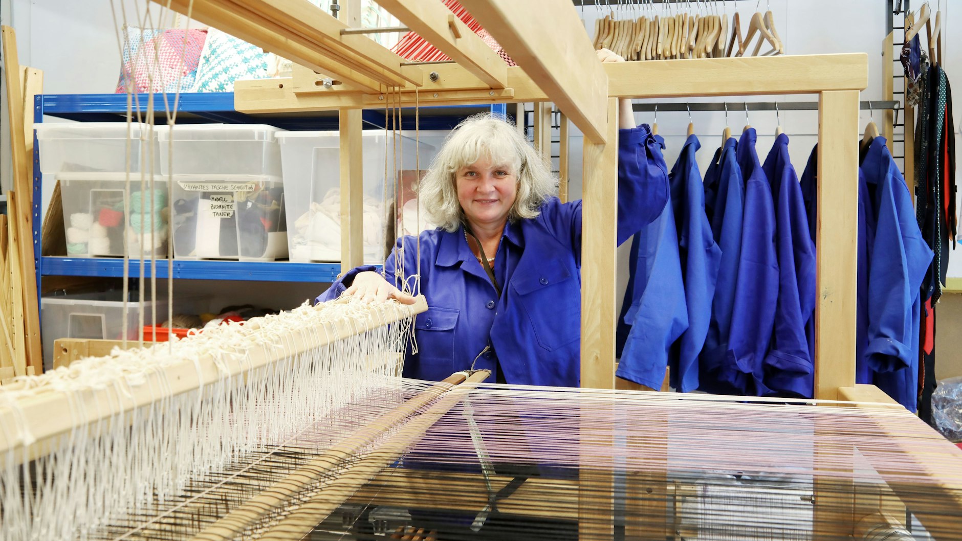 Ana Lichtwer (55) von der Stadtmission an einem Webstuhl, an dem Stoffreste verarbeitet werden. Nebenan werden aus Krankenhauskitteln Taschen.