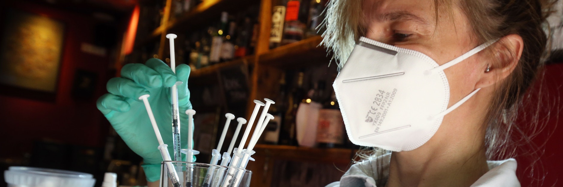 Eine medizinische Fachangestellte sortiert in der Revolte-Bar im Berliner Bezirk Friedrichshain Spritzen mit dem Impfstoff Johnson &amp; Johnson in einem Glas.&nbsp;&nbsp;