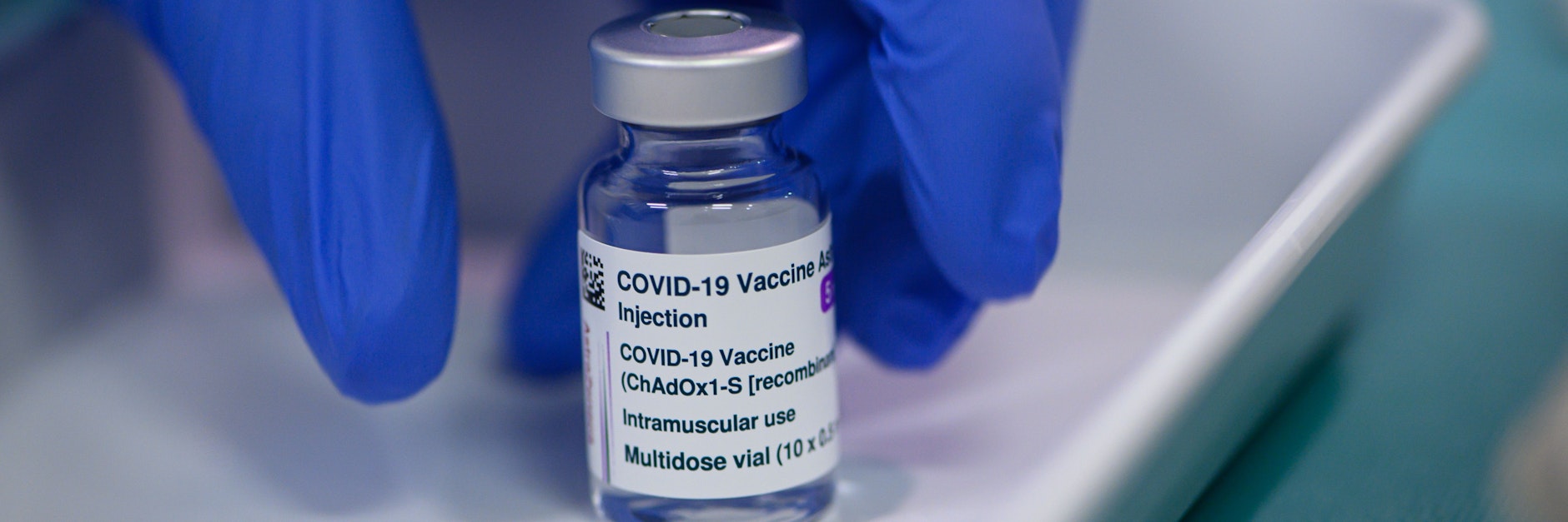 Ein Mitarbeiter im Impfzentrum in der Messe Dresden greift nach einer Ampulle des Impfstoffs Vaxzevria von&nbsp;Astrazeneca.