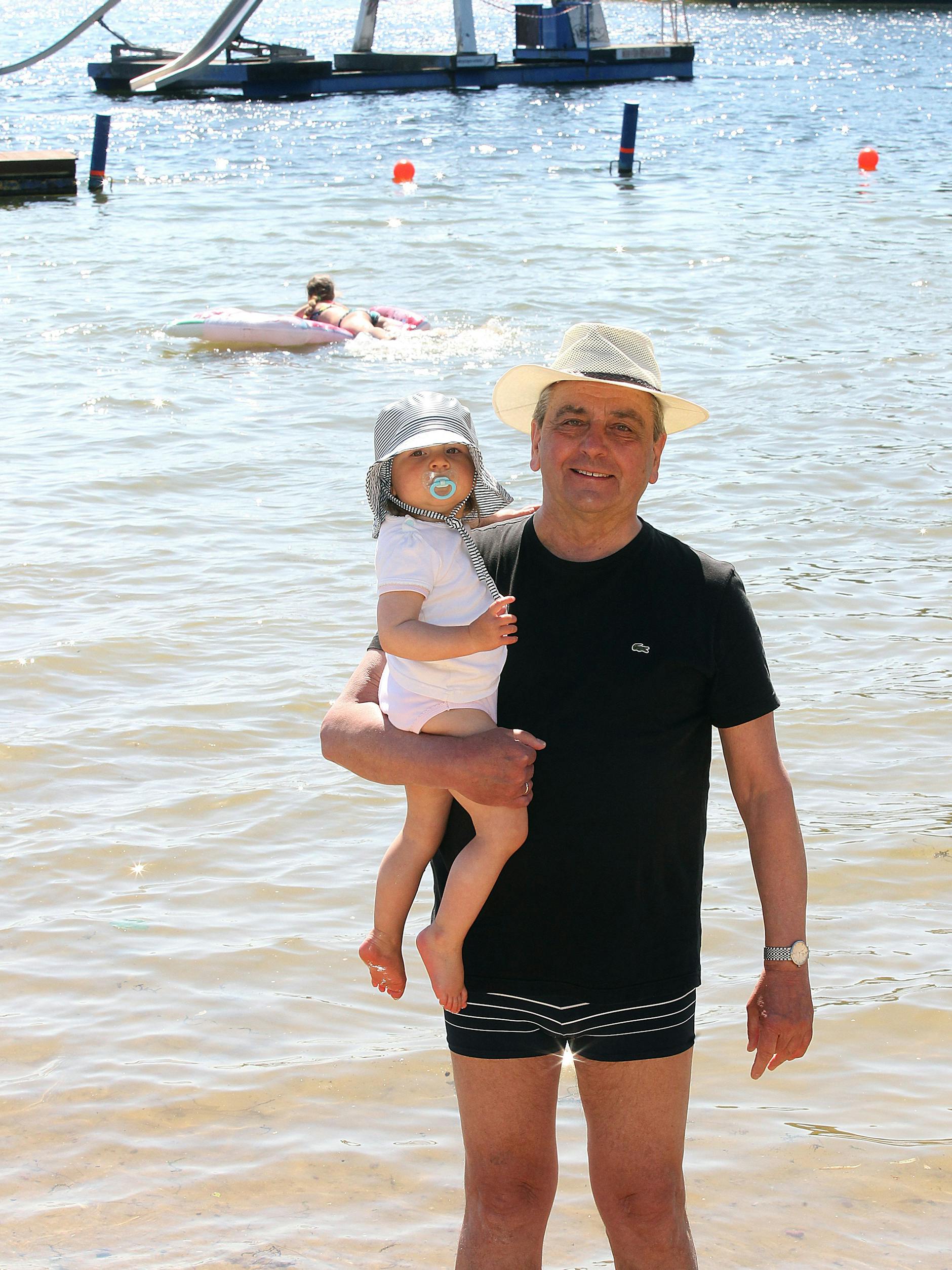 Roland Küster, mit Enkeltochter Isabell auf dem Arm, ist begeistert über die Wiedereröffnung des Strandbads.