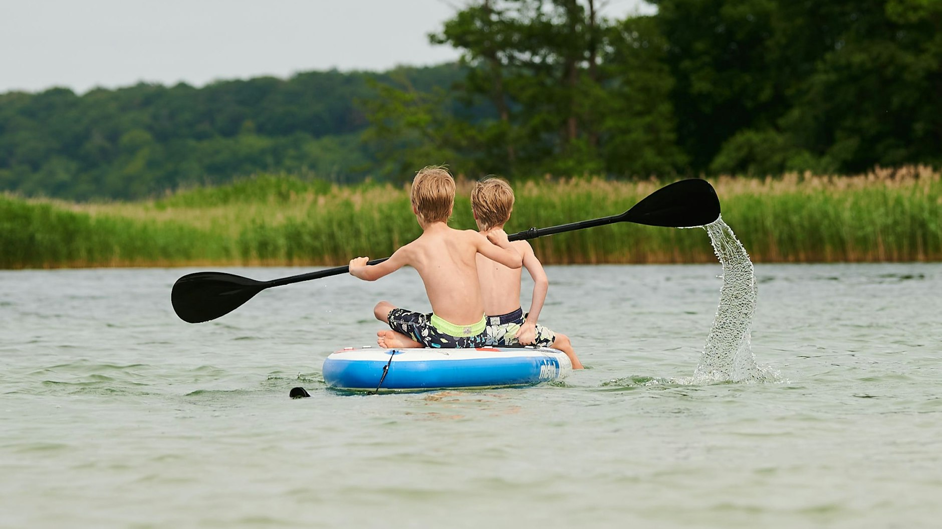 Zwei Kinder paddeln auf dem Werbellinsee auf dem Berolina Campingplatz.