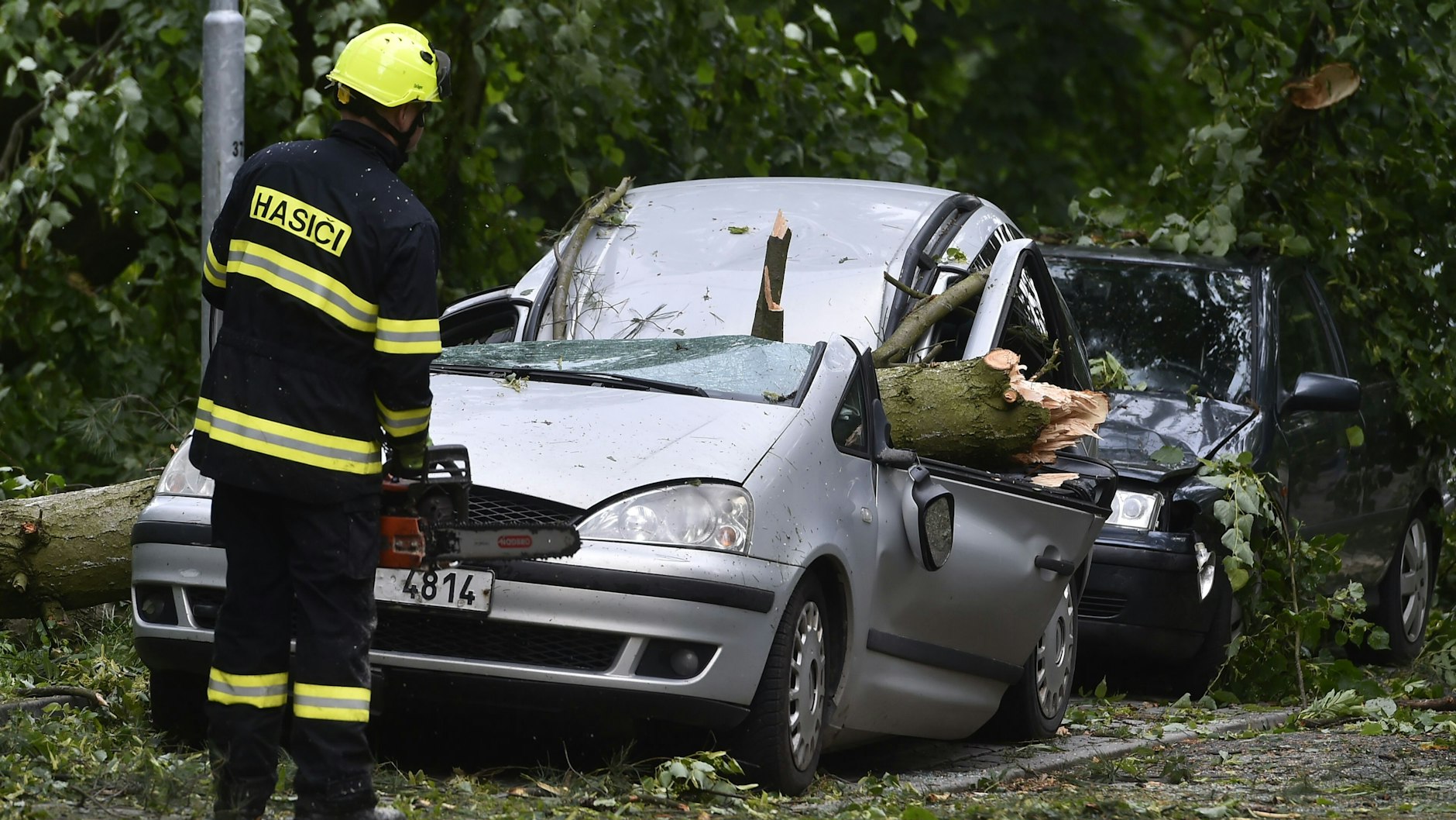 30.06.2021, Tschechien, Jihlava: Feuerwehrleute sind im tschechischen&nbsp;Jihlava&nbsp;im Einsatz, wo während eines nächtlichen Sturms Bäume auf geparkte Autos fielen.